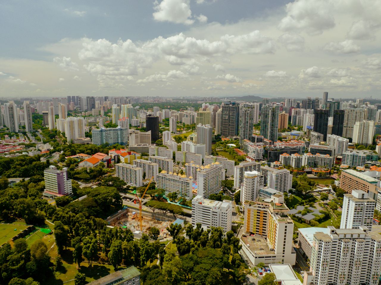 Stunning aerial photo showcasing Singapore's modern skyscrapers and lush greenery under a bright sky.