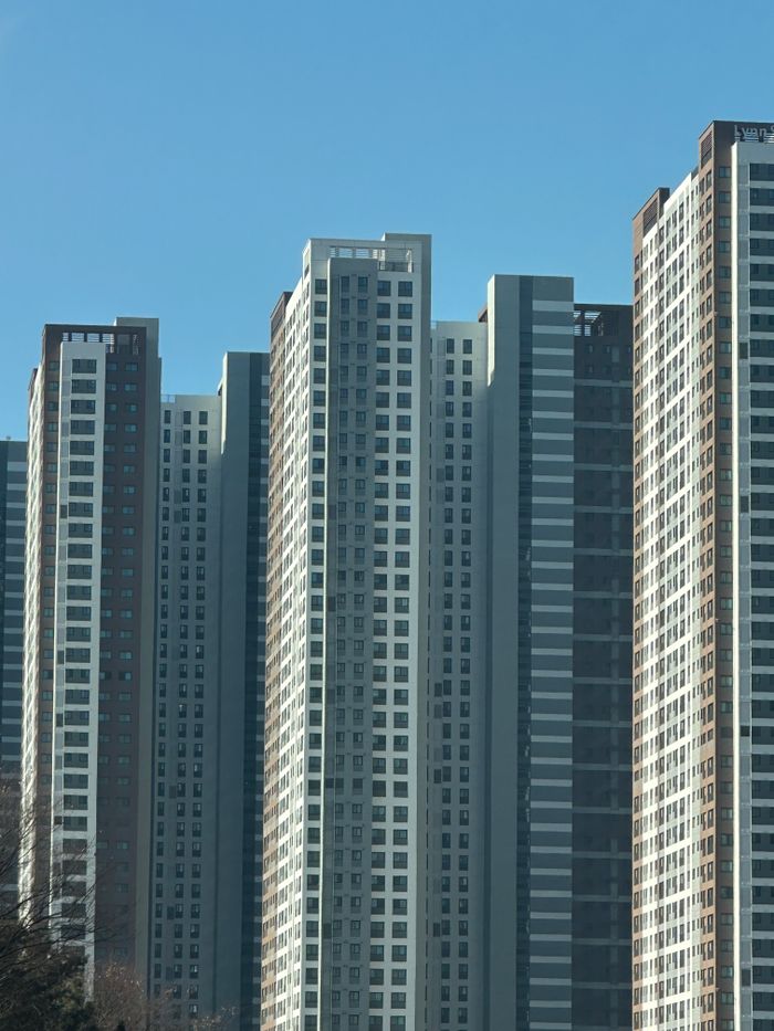 Tall modern apartment buildings with blue sky background, showcasing urban development and architecture